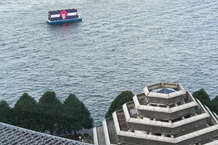 A LED billboard boat broadcasts the words "NEVER FORGET" off the coast of Lower Manhattan on Wednesday morning.